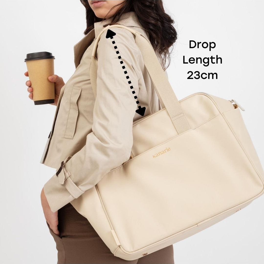 Woman holding a beige bag with a coffee cup, showing drop length measurement.